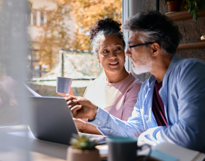 Retirement age adults watching a presentation on a laptop